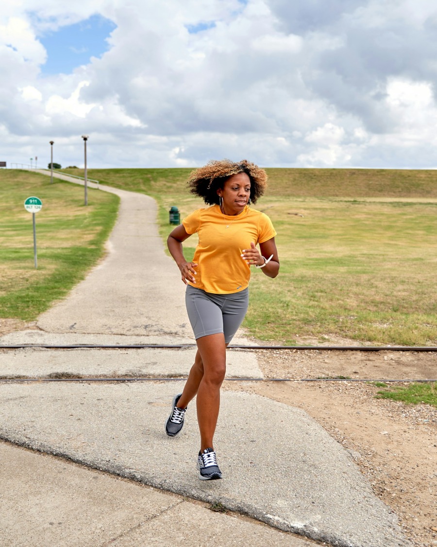 Black woman jogging outdoors on a park path